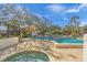 Community pool and hot tub, surrounded by lush landscaping at 4563 Trails Dr, Sarasota, FL 34232