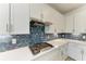 Gas cooktop with hexagonal backsplash and white cabinets at 4852 Coastal Days Ln, Bradenton, FL 34211