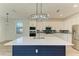 Modern kitchen with white cabinets, large island, and stylish lighting at 4852 Coastal Days Ln, Bradenton, FL 34211