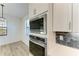 Modern kitchen with built-in microwave and oven, and hexagon tile backsplash at 4852 Coastal Days Ln, Bradenton, FL 34211