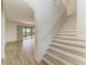 Modern staircase with wood-look treads and a view to the living room at 4852 Coastal Days Ln, Bradenton, FL 34211