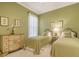 Charming bedroom with twin beds and calming green color scheme at 5781 Girona Pl, Sarasota, FL 34238