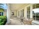 Relaxing covered patio with tile flooring, wicker chairs, and glass-top table at 5781 Girona Pl, Sarasota, FL 34238