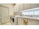 Bright laundry room, washer, dryer, and ample storage at 5781 Girona Pl, Sarasota, FL 34238