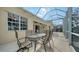 Screened patio with glass-top table and chairs, overlooks backyard at 5781 Girona Pl, Sarasota, FL 34238