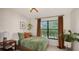 Bright bedroom with a comfy bed, large window, and stylish decor at 603 Barnes Pkwy, Nokomis, FL 34275