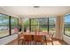 Sunlit dining area with wooden table and chairs, overlooking backyard at 603 Barnes Pkwy, Nokomis, FL 34275