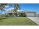 Light teal single story home with a green lawn and attached garage at 603 Barnes Pkwy, Nokomis, FL 34275