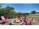 Inviting backyard fire pit surrounded by colorful Adirondack chairs and waterfront views at 603 Barnes Pkwy, Nokomis, FL 34275