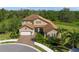 Two-story house with tile roof, large driveway and landscaping at 6229 Rivo Lakes Blvd, Sarasota, FL 34241