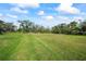 Spacious grassy backyard with mature trees at 6229 Rivo Lakes Blvd, Sarasota, FL 34241