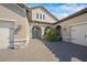 Front entry of the house featuring double arched entryways and stone accents at 6229 Rivo Lakes Blvd, Sarasota, FL 34241