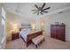 Comfortable bedroom featuring a ceiling fan, a wooden bed frame, and soft carpet flooring at 6347 Grandview Hill Ct, Bradenton, FL 34203