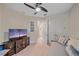 Bedroom featuring a comfortable daybed, television, ceiling fan, and ensuite bathroom at 6347 Grandview Hill Ct, Bradenton, FL 34203