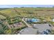 Aerial view of a community pool, playground, and tennis court surrounded by green spaces and mature trees at 6347 Grandview Hill Ct, Bradenton, FL 34203