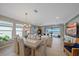 Bright dining room with modern chandelier open to living area and view of pool and lake at 6347 Grandview Hill Ct, Bradenton, FL 34203