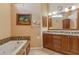 Bathroom with granite double vanity and wood cabinets at 6790 Paseo Castille, Sarasota, FL 34238