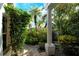 Landscaped side yard with a brick walkway and tropical foliage at 6790 Paseo Castille, Sarasota, FL 34238