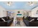 Living room with hardwood floors, two comfy sofas, and a view to the pool area at 7117 Queen Palm Cir, Sarasota, FL 34243