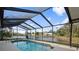 Inviting pool area with screened enclosure overlooking a tranquil lake at 7117 Queen Palm Cir, Sarasota, FL 34243