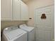 Laundry room with white cabinets and matching washer/dryer set at 735 Foggy Morn Ln, Bradenton, FL 34212