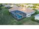 Aerial view of this charming home with a screened-in pool, spacious green lawn, and a lovely green shrubbery border at 7412 Links Ct, Sarasota, FL 34243