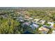 Beautiful aerial view of a home with a screened lanai in a lush, green community with mature trees and a golf course at 7412 Links Ct, Sarasota, FL 34243