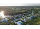 Aerial view of a home by a lake, featuring landscaped lawns and a serene residential neighborhood at 7412 Links Ct, Sarasota, FL 34243