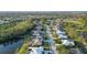 An aerial view of a home with a screened lanai nestled in a beautiful neighborhood with well-maintained landscaping at 7412 Links Ct, Sarasota, FL 34243