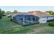 Aerial view of this charming home with a screened-in pool, spacious green lawn, and a lovely green shrubbery border at 7412 Links Ct, Sarasota, FL 34243