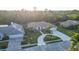 Aerial view of a beautiful suburban home featuring lush landscaping, a circular driveway, and a three-car garage at 7412 Links Ct, Sarasota, FL 34243