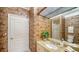 Bathroom with patterned wallpaper, granite counters, and a glass-door shower at 7412 Links Ct, Sarasota, FL 34243