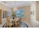 Bright dining room features an elegant chandelier, decorative rug, and display cabinet at 7412 Links Ct, Sarasota, FL 34243