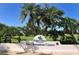 Palm Aire Country Club Champions Course entrance sign with palm trees against a clear blue sky at 7412 Links Ct, Sarasota, FL 34243