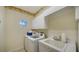 Well-lit laundry room features a washer, dryer, sink, and storage cabinets at 7412 Links Ct, Sarasota, FL 34243