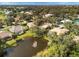 Aerial view of community featuring houses, lake, and lush greenery at 804 Connemara Cir, Venice, FL 34292