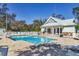 Resort-style pool featuring a building with stone accents, lounge chairs, and a white picket fence at 804 Connemara Cir, Venice, FL 34292