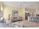 Open living room with a view of the kitchen, featuring a sofa and a comfortable ottoman at 804 Connemara Cir, Venice, FL 34292