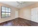 Bedroom with large window, wood floors and ceiling fan at 8335 38Th Street E Cir # 303, Sarasota, FL 34243