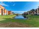 Exterior view of a condo community with a tranquil lake and lush landscaping at 8335 38Th Street E Cir # 303, Sarasota, FL 34243