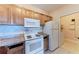 Kitchen with wood cabinets, granite countertops, and white appliances at 8335 38Th Street E Cir # 303, Sarasota, FL 34243