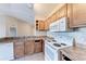 Kitchen with wood cabinets, granite countertops, and white appliances at 8335 38Th Street E Cir # 303, Sarasota, FL 34243