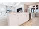 White kitchen island with quartz countertop and stainless steel dishwasher at 8497 Pavia Way, Bradenton, FL 34202