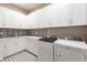 Bright laundry room with white cabinets, modern washer and dryer, and stylish tile at 8497 Pavia Way, Bradenton, FL 34202