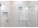 White tiled shower with glass door and small window at 8497 Pavia Way, Bradenton, FL 34202