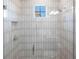 Elegant shower with frameless glass enclosure and subway tile at 8497 Pavia Way, Bradenton, FL 34202