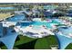 Aerial view of a luxurious community pool area with cabanas, lounge chairs, and lush landscaping at 9405 Ballaster Pointe Loop, Parrish, FL 34219