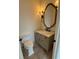 Elegant powder room with a pedestal sink, vanity, and decorative mirror at 1023 Tocobaga Ln, Sarasota, FL 34236