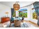 Bright dining room with glass table, wicker chairs, and view of lush landscaping at 1023 Tocobaga Ln, Sarasota, FL 34236