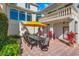 Outdoor patio with dining table and seating under a yellow umbrella at 1023 Tocobaga Ln, Sarasota, FL 34236